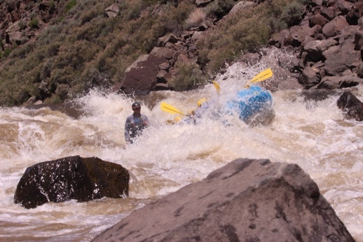 a man riding a wave on top of a rocky mountain